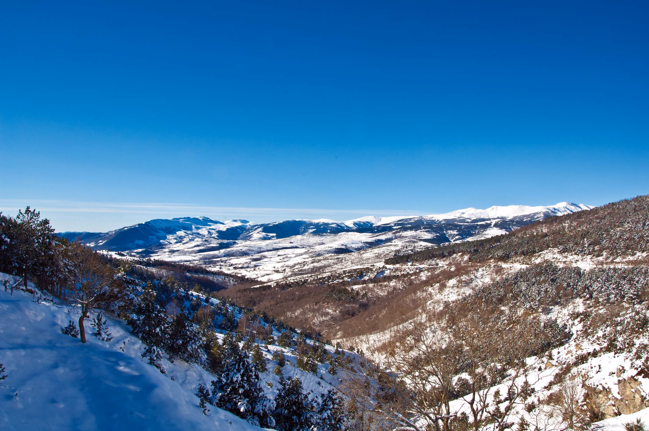 Schneebedeckte Berglandschaft bei Molló mit weitem Blick